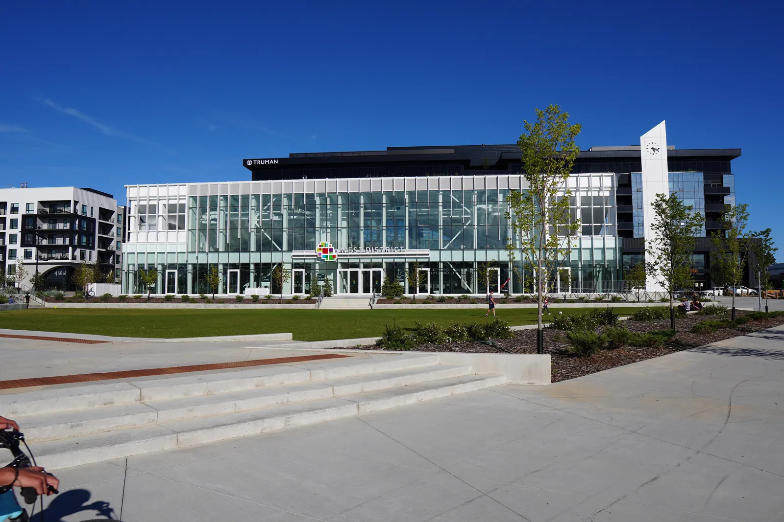 glass commercial building behind wide steps, deep blue sky, very calm